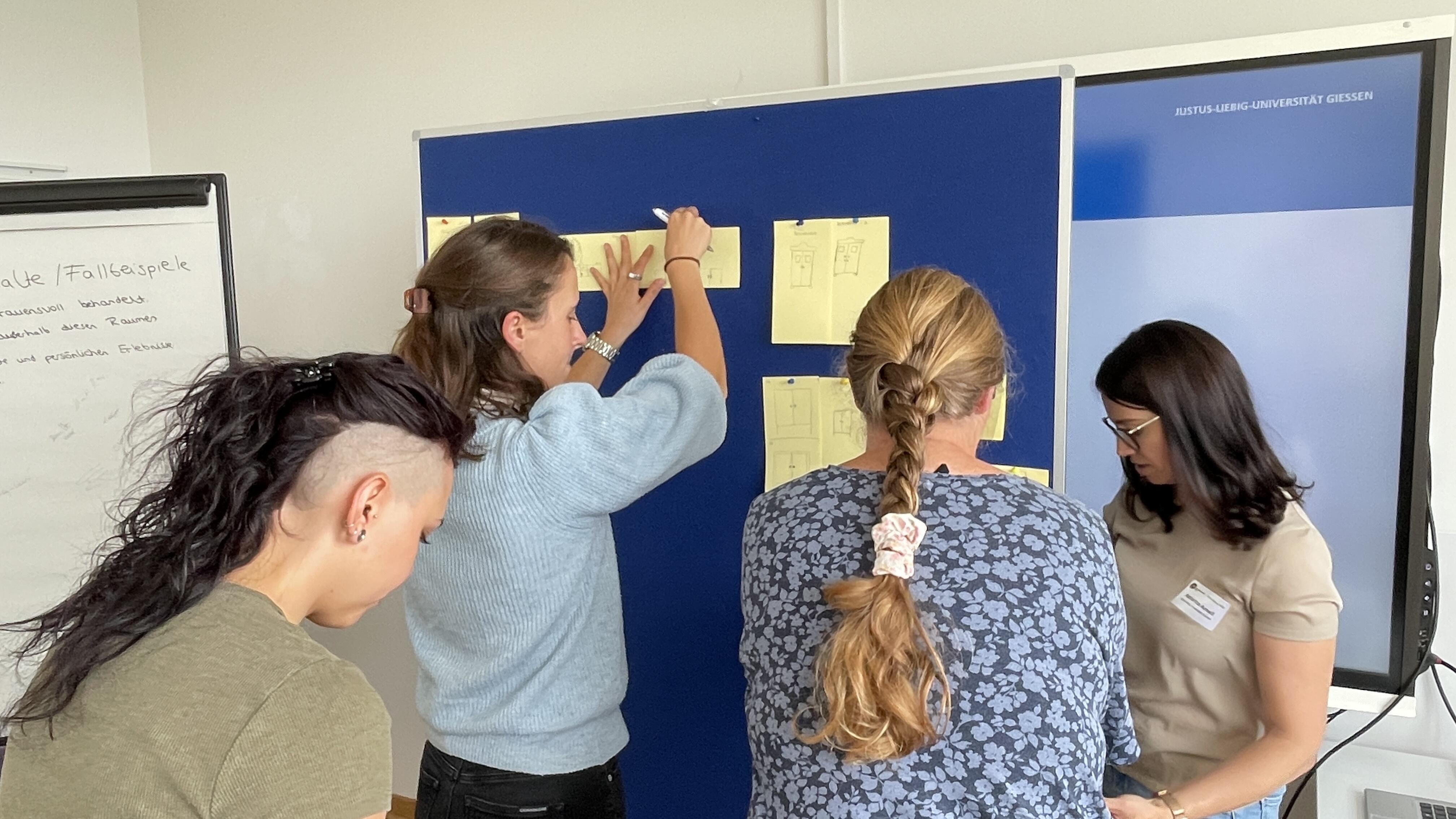 The participants compare their drawings of a cupboard as a communication exercise.