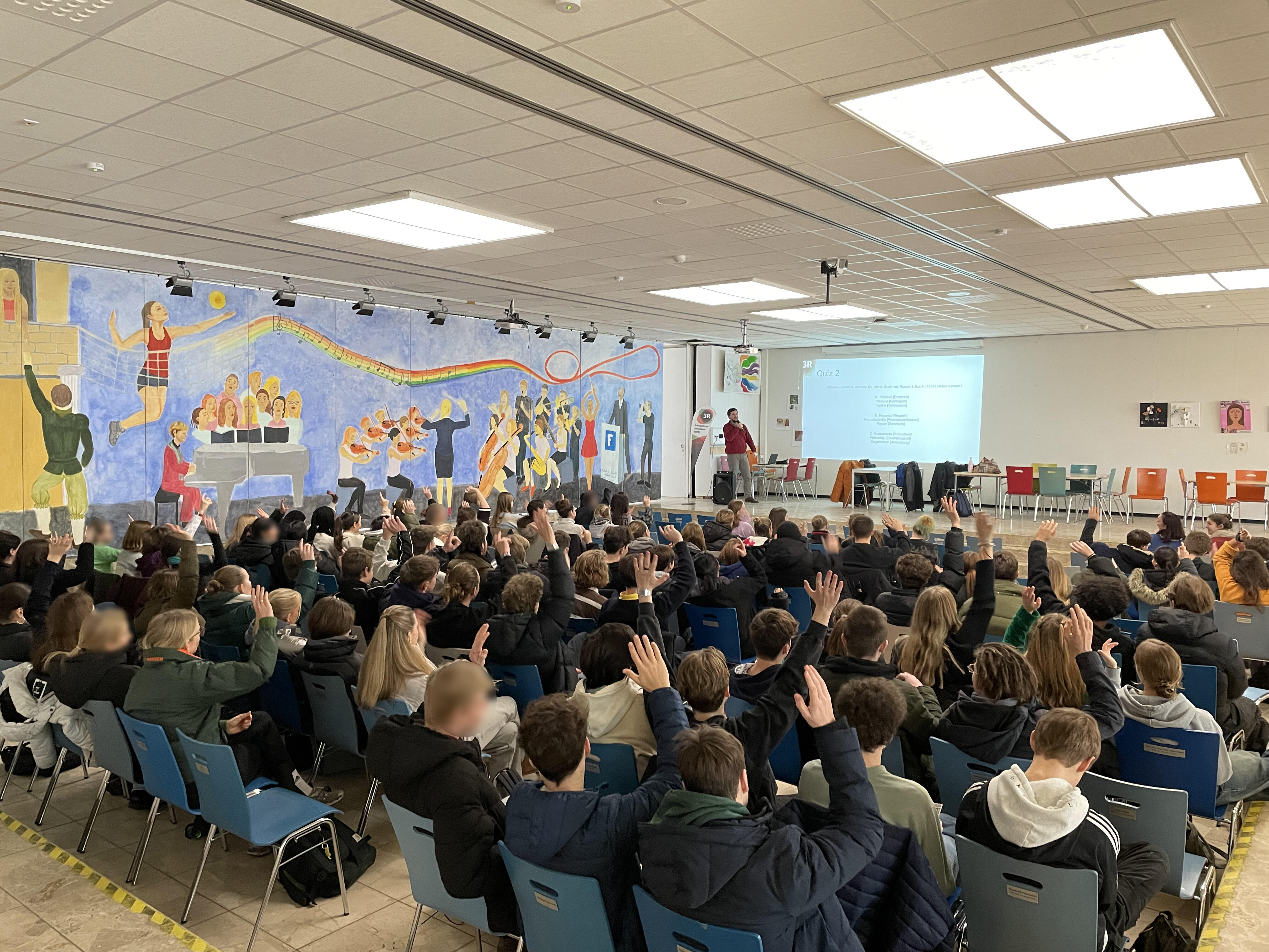Die Schülerinnen und Schüler heben die Hände für eine Quizfrage im Gymnasium Fabritianum.